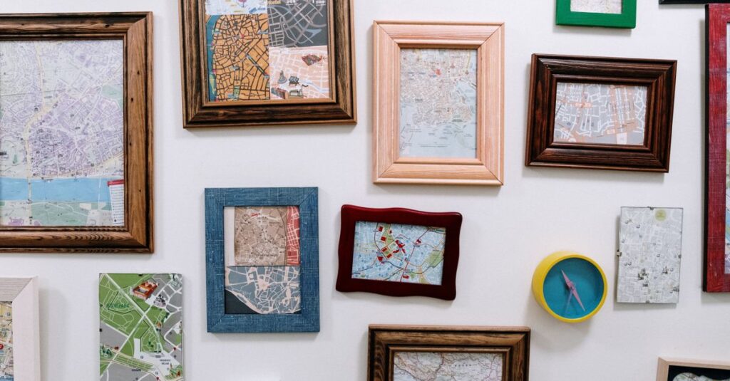 A gallery wall of framed prints in mixed wooden and coloured frames, hung edge to edge on a white wall.