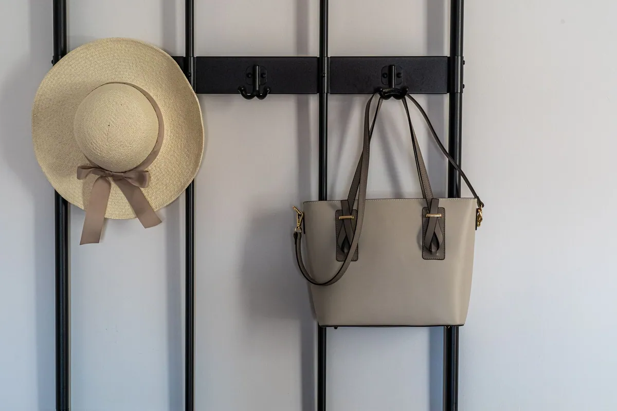 Removable adhesive wall hooks holding a framed print on a wall without drilling