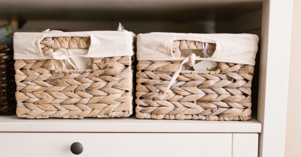 Two woven storage baskets with white fabric liners, sitting side by side on a shelf.